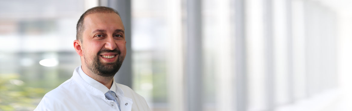 Jalal Aouf im weißen Kittel in einem Flur des Krankenhauses