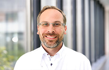 Dr. med. Florian Kessler im Portrait im weißen Kittel