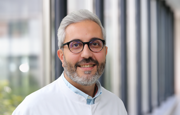 Dr. med. Mahmoud Jbara El Bayaa im weißen Kittel im Flur des Krankenhauses