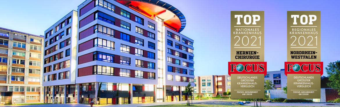 Der Neubau des Rhein-Maas Klinikums in der "blauen Stunde". Dahinter Bettenhaus und geriatrisches Bettenhaus. Fotografie von einer Wiese aus. Rechts sind zwei Siegel des Focus-Magazins zu sehen: Top nationales Krankenhaus Hernienchirurgie 2021 und Top regionales Krankenhaus Nordrhein-Westfalen 2021