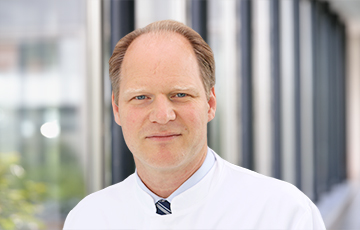 Prof. Dr. med. Jens Tischendorf im Portrait im weißen Kittel