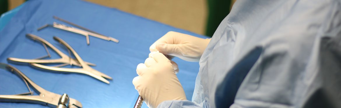 Een persoon plaatst steriele chirurgische instrumenten op een tafel bedekt met een blauwe doek
